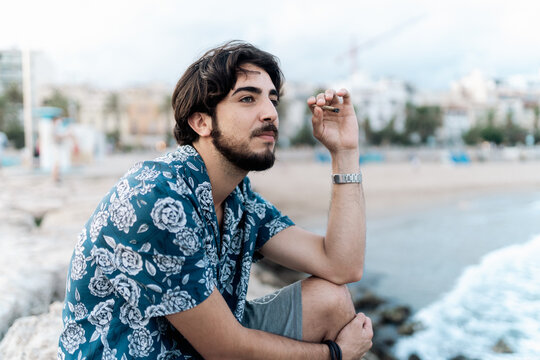 Young man smoking marihuana at the beach