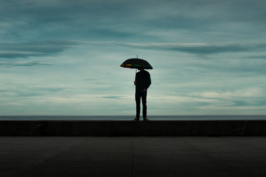 Standing man holding an umbrella