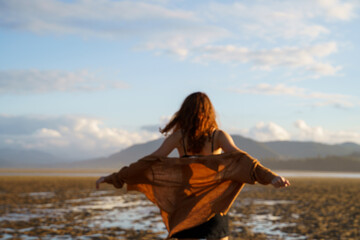 Woman dancing in nature at sunset
