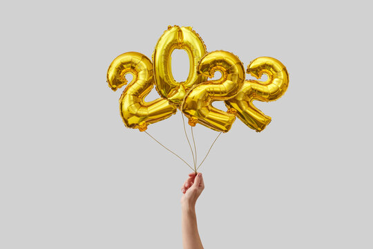 Woman holding 2022 balloons