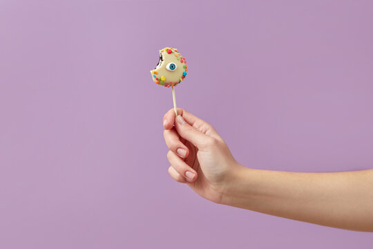 Woman holding eye lollipop
