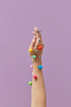Female arm with colored pompons and eyes