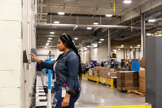 Black Employee punching Time Clock   at Work 