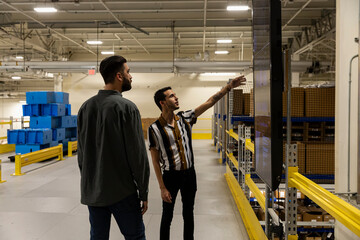 Worker looking up at work status board at factory