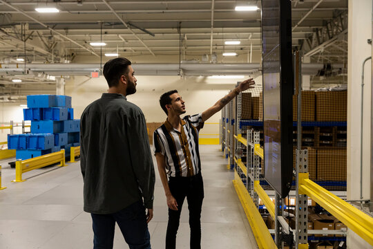 Worker looking up at work status board at factory