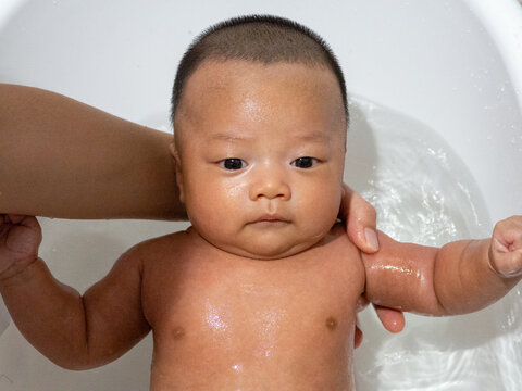 Baby Asian and nationality Thai is bathing in a white basin
