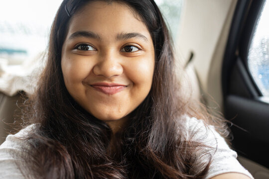 A teenage Indian girl with facial expressions inside car