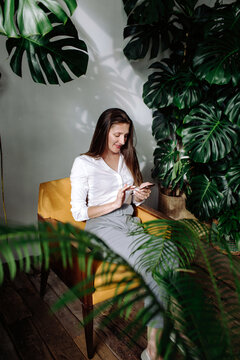 Woman using smartphone amidst plants
