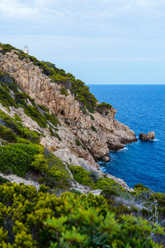 Ridge against sea under cloudy sky