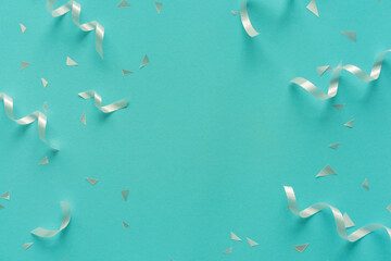 close up on group of white color of rolling ribbon and confetti on teal background with copy space...