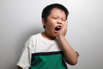 Portrait of a little Asian boy suffering from toothache - Dental problem. 