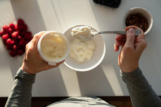 Making muesli breakfast with yoghurt