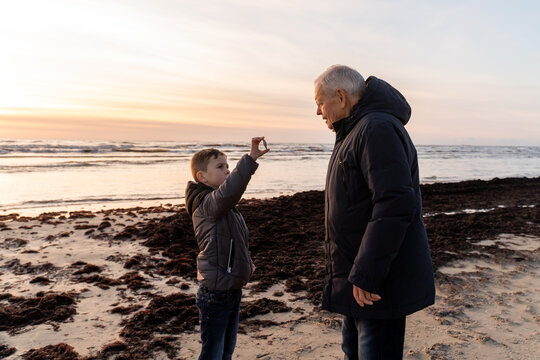 Grandfather And Grandchild In The Beach