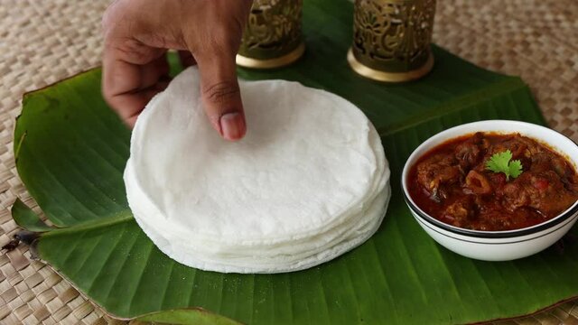 Rice Pathiri pathir flat bread spicy chicken curry woman hand serving traditional South Indian breakfast dish Rice roti 4K video footage Malabar Ramadan Ramzan, Eid festival Kerala India SriLanka
