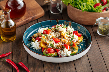Grilled vegetables salad with cheese on wooden background