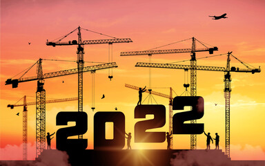 Silhouette staff works as a to prepare to welcome the new year 2022. Large construction site, many construction cranes set numbers 2022. Construction team sets numbers for New Year 2022. Vector.