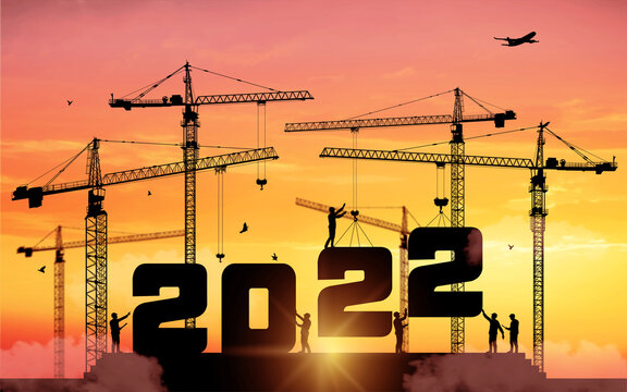Silhouette staff works as a to prepare to welcome the new year 2022. Large construction site, many construction cranes set numbers 2022. Construction team sets numbers for New Year 2022. Vector.
