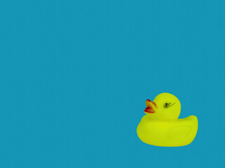 Children's toy bird yellow duckling on a blue background of water. Duck bird. Kids toys. Blue water color background. Little ducklings. An object of entertainment for kids.