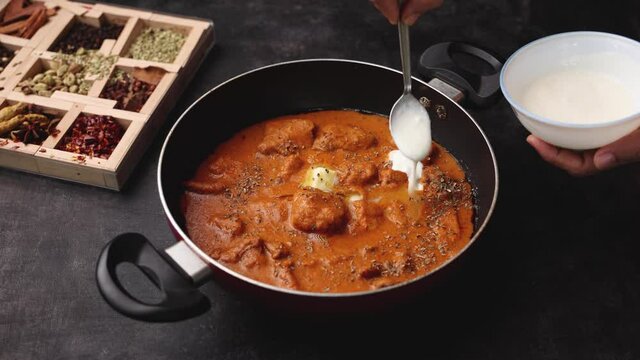 Butter chicken woman hand serving cooking Murgh Makhani curry roast Vindaloo hot spicy dish 4K video footage Dhaba Punjab India North Indian non vegetarian cuisine tikka Masala Chicken curry 