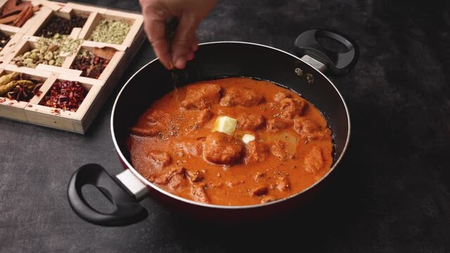 Butter chicken woman hand serving cooking Murgh Makhani curry roast Vindaloo hot spicy dish 4K video footage Dhaba Punjab India North Indian non vegetarian cuisine tikka Masala Chicken curry 