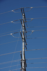 Electricity distribution pylon and cables under bright blue sky