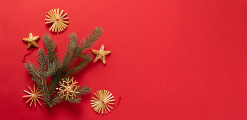 Fluffy branches of fir-tree Christmas toys made from natural materials of straw, red background. concept Christmas New Year.
