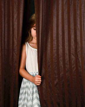 Shy Child Hiding Behind Curtain