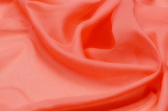 Close-up texture of natural red or pink fabric or cloth in same color. Fabric texture of natural cotton, silk or wool, or linen textile material. Red canvas background.