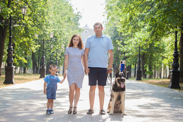 A family of three on a walk with the dog. German Shepherd