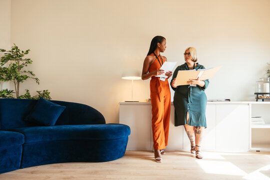 Multiracial Women Discussing Data In Workplace