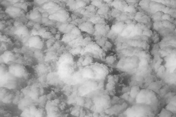 Stratosphere, a view of clouds from an airplane window. Black and white photo. Cumuliform cloudscape on sky.