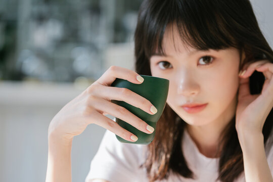 Girl holding coffee cup and looking at camera