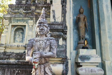 Obraz premium A giant statue of Brahmanism and Hinduism is placed in front of the entrance to an ancient stone temple.