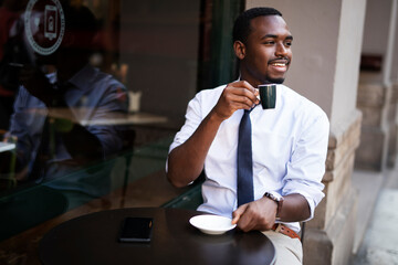 African businessman drinking coffee in cafe. Happy smiling man enjoy in fresh coffee..