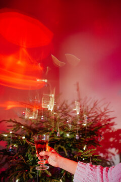 Hand with champagne against Christmas tree