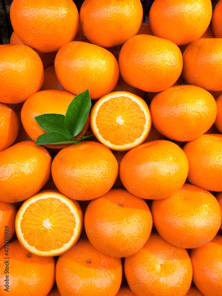 Wall mural fresh orange fruits with leaves as background, top view