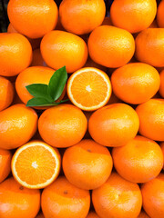 fresh orange fruits with leaves as background, top view