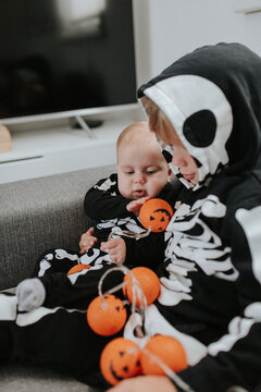 Little boy celebrating Halloween with his infant brother