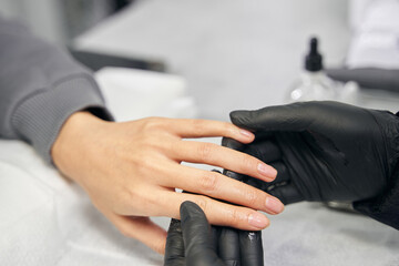 Obraz premium Unrecognized female client receiving nails treatment in salon