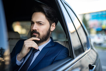 A handsome young businessman is driving in the car