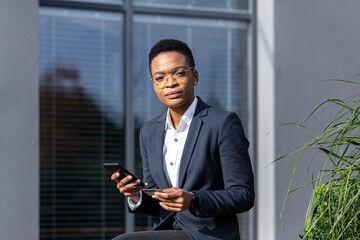 Annoyed and tired African-American woman tries to make an online purchase, uses a phone application and a credit card, fails to complete the transfer