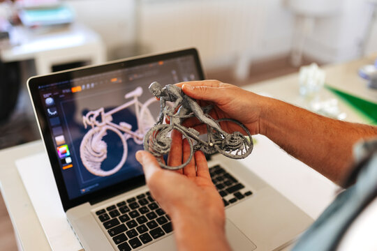 Crop man holding a 3D figure of a cyclist
