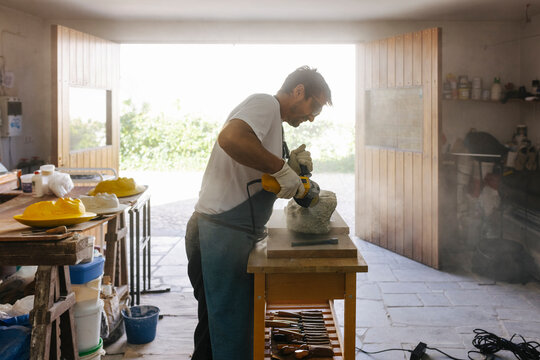 Focused artisan working with stone detail in workshop