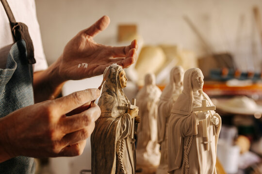 Crop artisan working with clay virgins in workshop