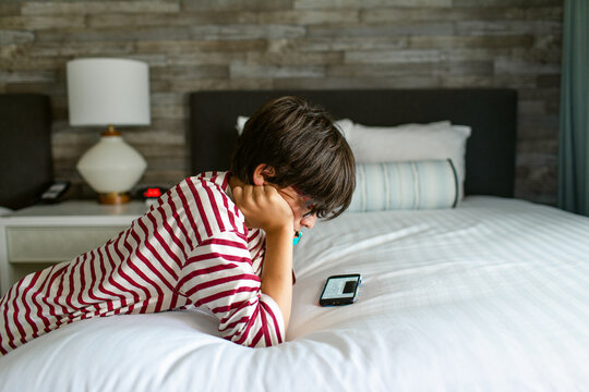Boy using smartphone in hotel room