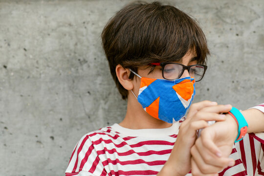 Teen with mask looking at the time