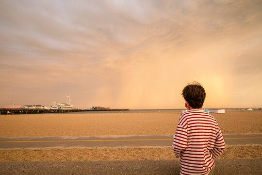 Boy watching sunset at the beach