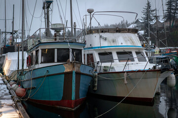 Fototapeta premium White and green boats on a snowy winter dock in British Columbia