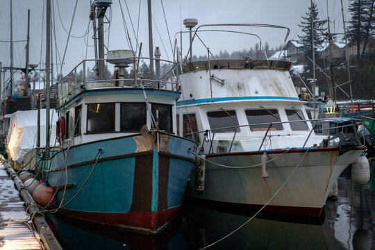 White and green boats on a snowy winter dock in British Columbia