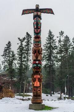 Colourful totem pole in British Columbia Canada in the winter snow